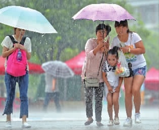进入6月，长沙已经历3次强降雨。图为湘府西路，市民撑伞在大雨中出行。记者 李健 摄