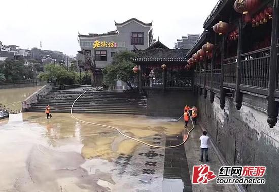 湘西吉首乾州古城，万溶江水位开始下降，但沿河景点警戒线仍未撤离，值班人员继续加强值班并开始清扫工作。