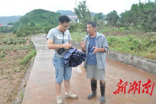 李久忠向当地记者介绍灾情