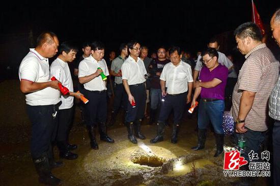 岳阳市委常委、统战部长熊炜(左三)在沙田垸坐镇指挥防汛救灾。