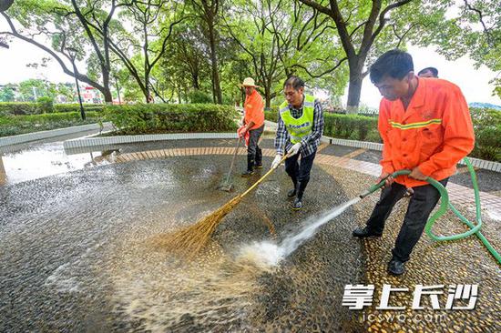 利用高压水枪冲洗配合地面清扫，地面的泥沙很快被冲洗干净。