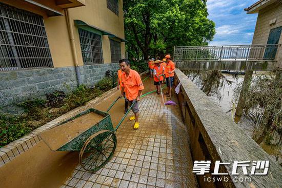 环卫工人正在清理湘江风光带沿线积泥、积沙。