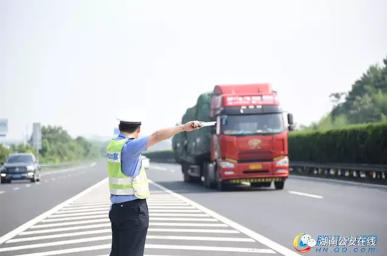 谢文在交叉口上对经过的大型车辆进行指挥