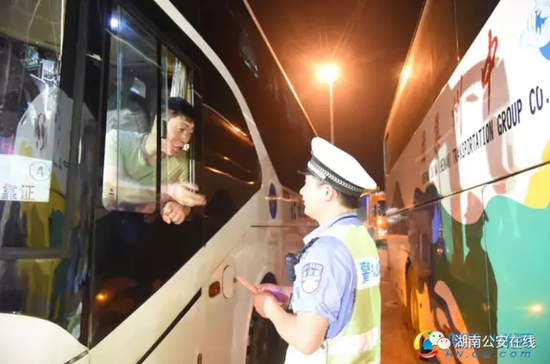 谢文在警务站例行检查客运车司机驾照