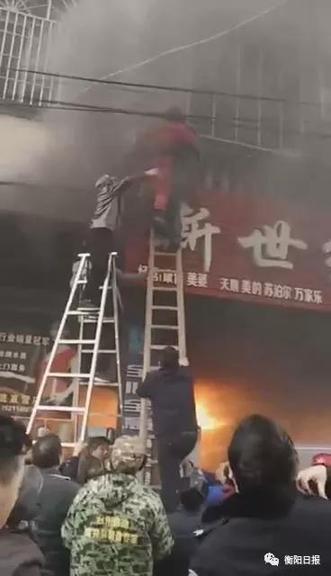 ▲彭灵麟登上长梯砸开“生命通道”,将被困母亲(穿红衣者)和两个孩子救出。(现场视频截图)