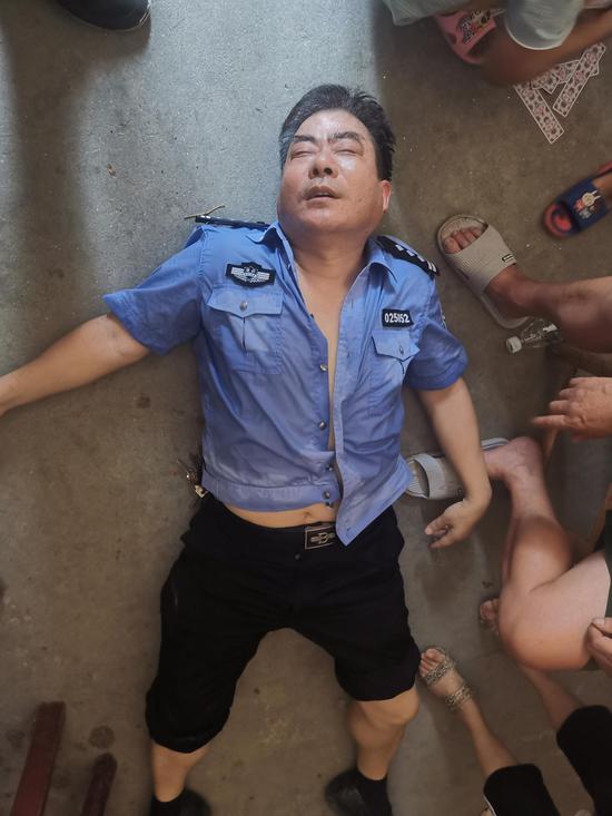 图为民警黄惠民因连日作战，劳累中暑倒地