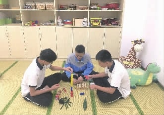 5月31日，长沙信息职业技术学校学前教育专业1706班三位男生正在实训室里练习积木游戏。记者 黄京 实习生 管婷 摄