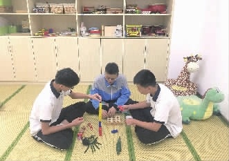 5月31日,长沙信息职业技术学校学前教育专业1706班三位男生正在实训室里练习积木游戏。记者 黄京 实习生 管婷 摄