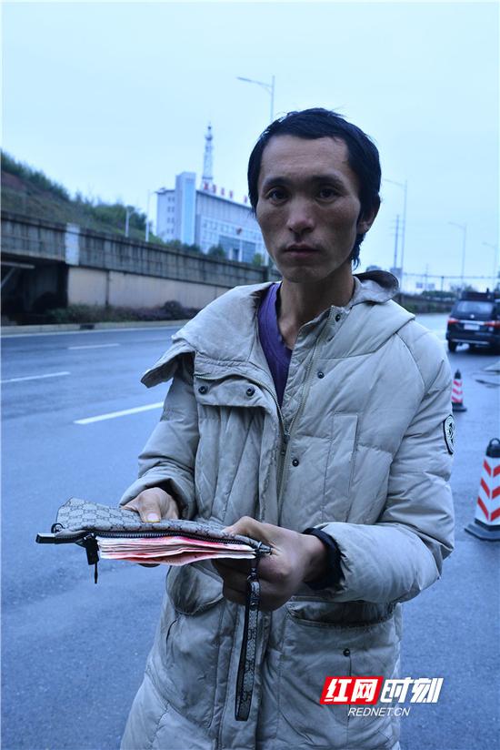 何小全和他捡到的钱包。(摄影 唐翔)