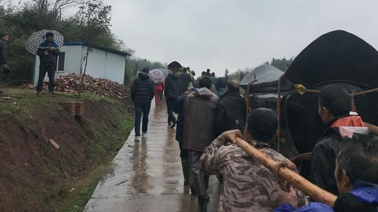 上午8时40分许,被儿子锤杀的罗某夫妇,被亲友们送至家对面的山坡上,入土为安。新京报记者段睿超 摄