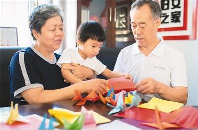 活动现场,老年夫妇代表一起折千纸鹤 丁根厚摄(人民视觉)