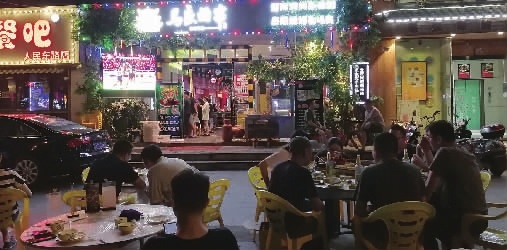 6月22日，不少消费者聚集在太平街一家烧烤店外的大屏前看球。 记者 朱蓉 摄