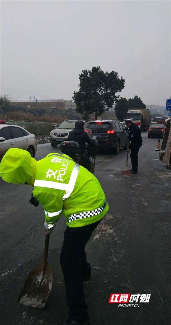 交警铲除路面积雪保畅通。