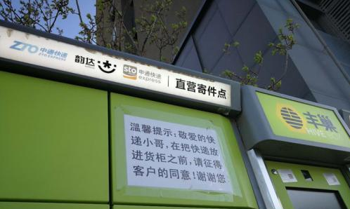 北京市某小区外的快递柜上张贴提示,提醒快递员放进货柜前首先征得收件人同意