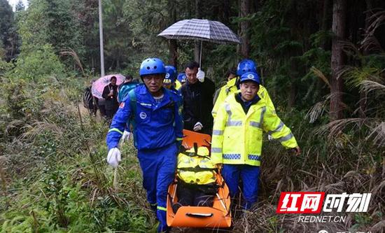 老人被邵东县蓝天救援队抬下山。