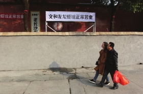 12月6日,长沙湘江中路,文和友老长沙龙虾馆在水泥墙后打出“正常营业”的牌子,以吸 引食客就餐。组图/记者金林辜鹏博谢长贵