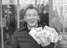 2月7日,65岁的郑湘午用从法院领到的支票在银行换到钱后,非常开心。 图/记者华剑