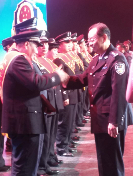 李晓葵亲自为这些从警30年以上的老民警颁发纪念勋章并握手致敬