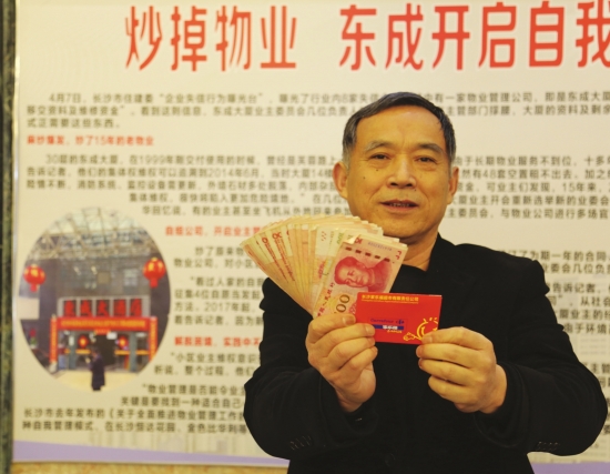 2月9日,长沙东成大厦,物业人员展示自己领到的奖金和500元购物卡。图/记者金林实习生张云峰