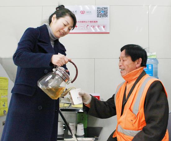 中国银行益阳分行员工正在为环卫工人倒上一杯甘甜的暖心茶。刘盛/摄