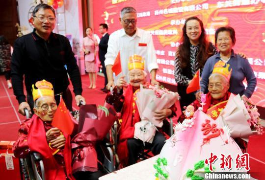 图为当地民众向百岁老人贺寿。 施华健 摄
