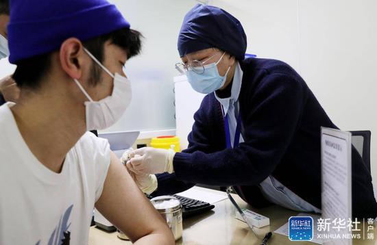 ↑1月7日,上海市徐汇区康健街道社区卫生服务中心医务人员为即将出国留学的市民注射疫苗。新华社记者方喆摄