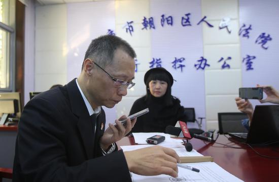 法官在和当事人肖先生通话。摄影:新京报记者王贵彬