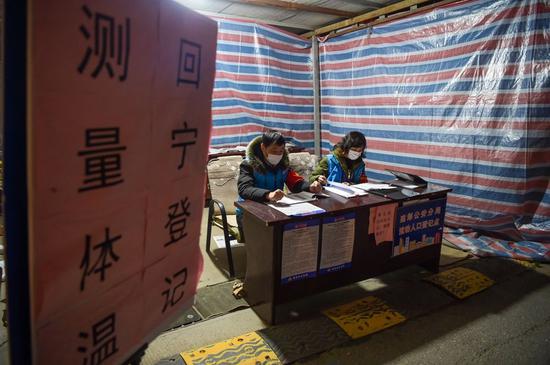 2月17日晚,网格员范璐(右)和同事在南京市建邺区兴达新寓小区门口的防疫服务点值守。 新华社记者李博摄