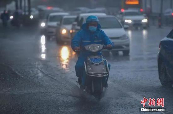 图为外卖小哥在暴雨中骑行。骆云飞 摄