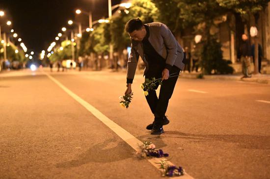 在车队到来之前,当地群众在街道中间摆上鲜花祭奠英雄。