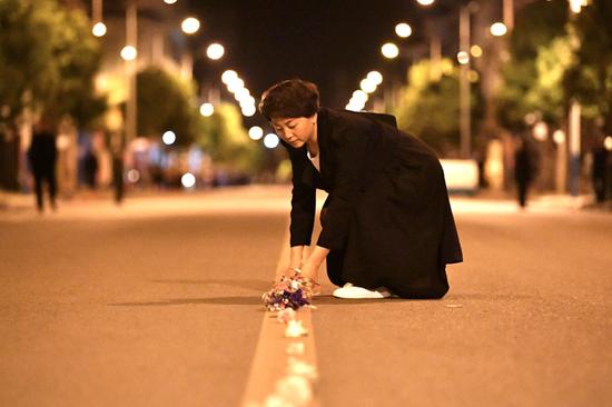 在车队到来之前,当地群众在街道中间摆上鲜花祭奠英雄。