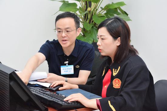 一起案件的中立评估结束后,当事人双方达成了调解,法官正为他们出具调解书。受访者供图
