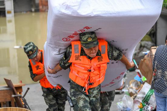 8月18日，在重庆北碚区水土街道，武警重庆总队机动支队官兵在帮助群众抢运物资。 
