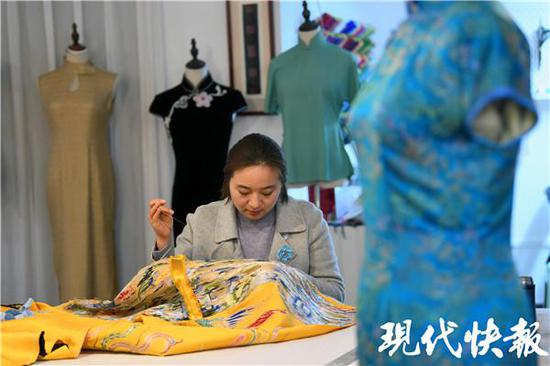 △季月琴一针一线在布料上做着平绣