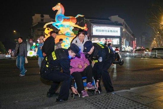  图释：民警帮助行动不便的外地游客过马路 拍摄：刘叙麟