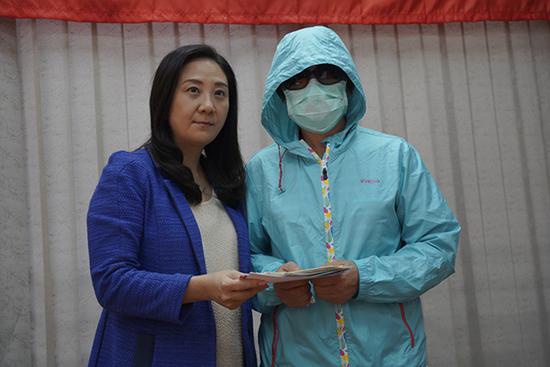 11月20日下午,香港日前(11日)被暴徒烧伤的李伯太太(右)现身,民建联香港立法会议员葛珮帆陪同出现。