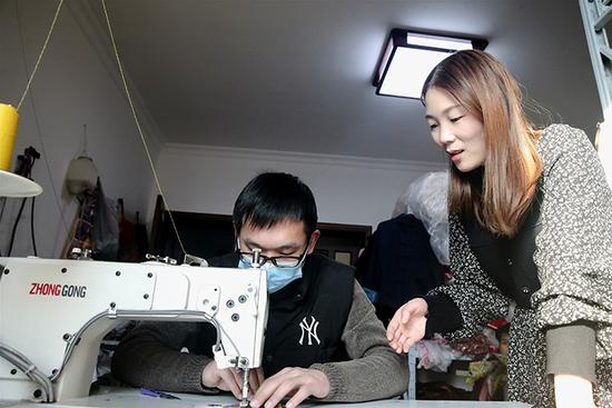 任赛男和制衣师傅沟通寿衣款式。