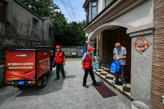 8月23日，彭福村志愿者正在为村民运送物资。南报融媒体记者 董家训 摄