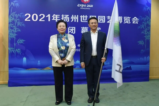 中国花卉协会会长江泽慧向2024年世园会承办单位成都市副市长刘玉泉授国际园艺生产者协会(AIPH)会旗