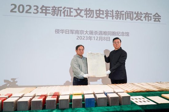 　　2023年12月8日，美籍华人鲁照宁（左）向侵华日军南京大屠杀遇难同胞纪念馆捐赠了125份美国报纸。 新华社记者李博 摄