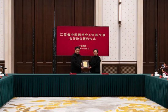 李雨航主席向翟优会长颁发“国际文艺传播指导”聘书