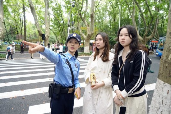 &nbsp;▲玄武分局民警在梧桐大道帮外地游客指路。拍摄：孙斌