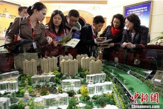 资料图:购房人在楼盘看沙盘并咨询售楼工作人员。中新社发 汤彦俊 摄