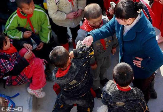 ▲图文无关,图为某老师一边训斥学生,一边举手敲打学生的脑袋。图/视觉中国