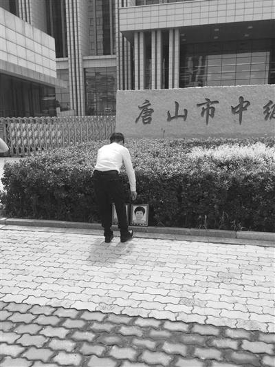 廖海军激动不已,在法院门口叩拜父母,告知判决结果。 律师李长青供图