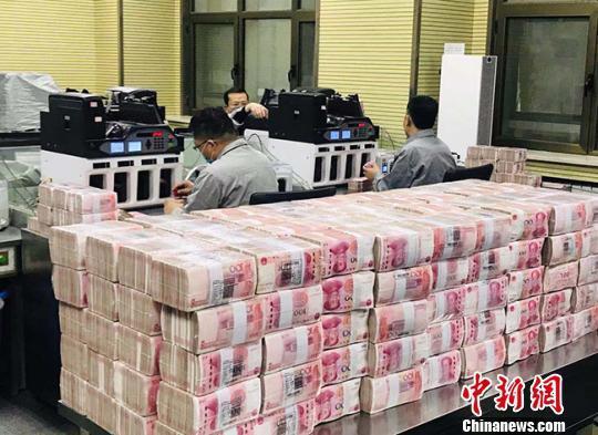 资料图:银行点钞员在工作。艾庆龙 摄