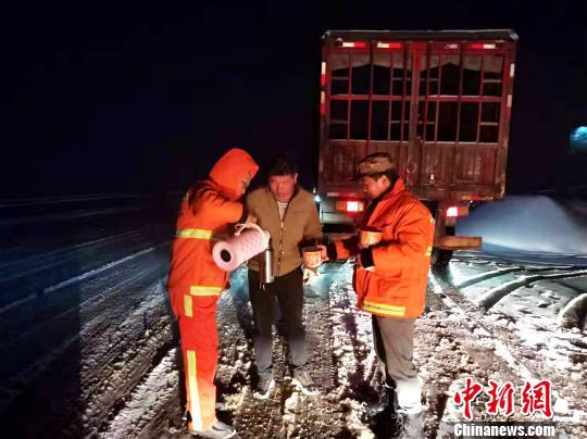 图为公路部门职工为卡车司机送方便面。李学鹏 摄