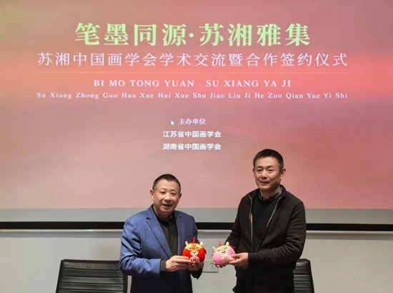 江苏省中国画学会监事长王强向湖南省中国画学会会长石劲松赠送“福豹平安”玩偶