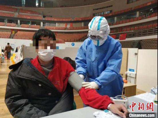 胥跃帮助患者测量血压。 严都仁 摄