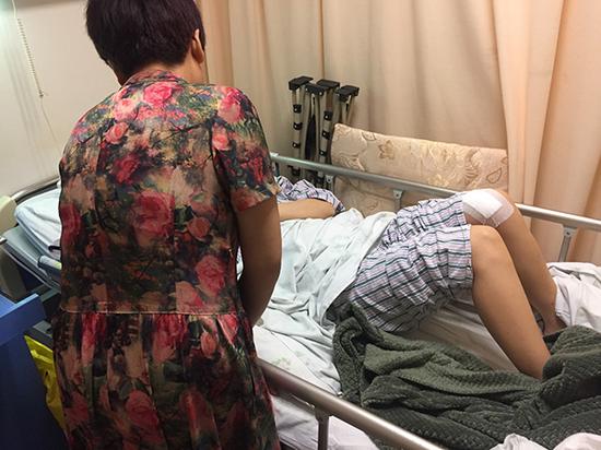 黄小妮躺在医院病床上,母亲在身旁照顾。澎湃新闻见习记者 李佳蔚 图